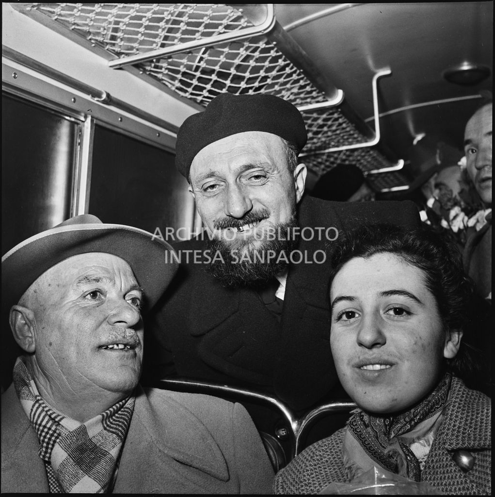 Ex prigioniero italiano di rientro in patria in posa su un autobus in compagnia di due persone<br>196446