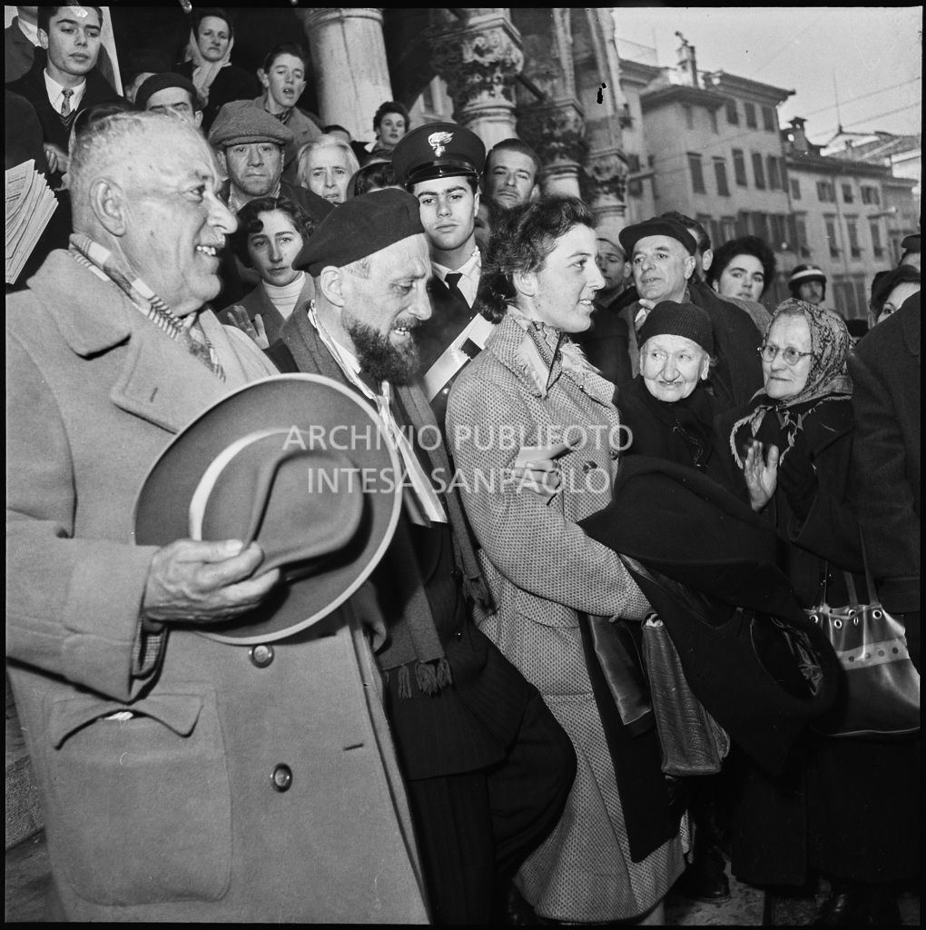 Ex prigioniero italiano di rientro in patria accolto dalla folla in Pazza della Libertà a Udine, sulle scale della Loggia del Lionello<br>196449