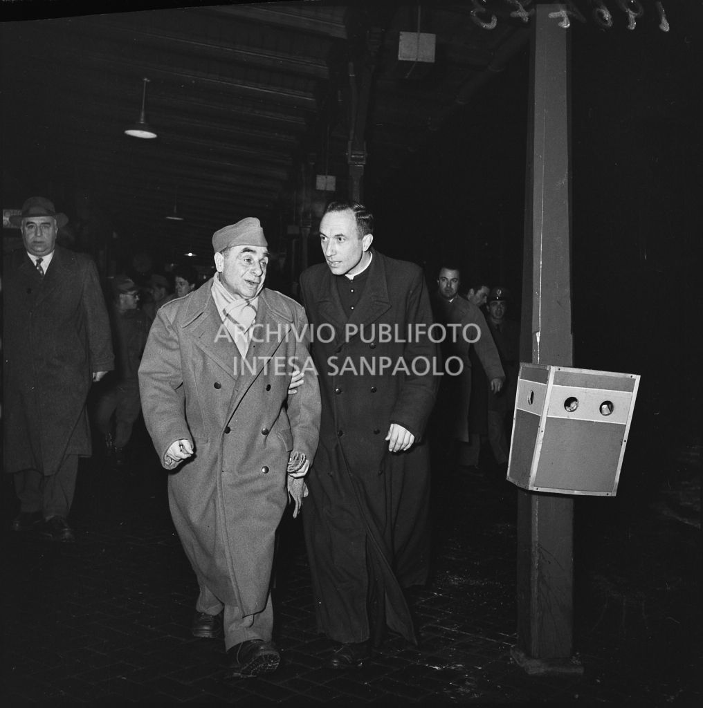 Ex prigioniero italiano di rientro dall'Unione Sovietica in una stazione ferroviaria in compagnia di un sacerdote<br>196473