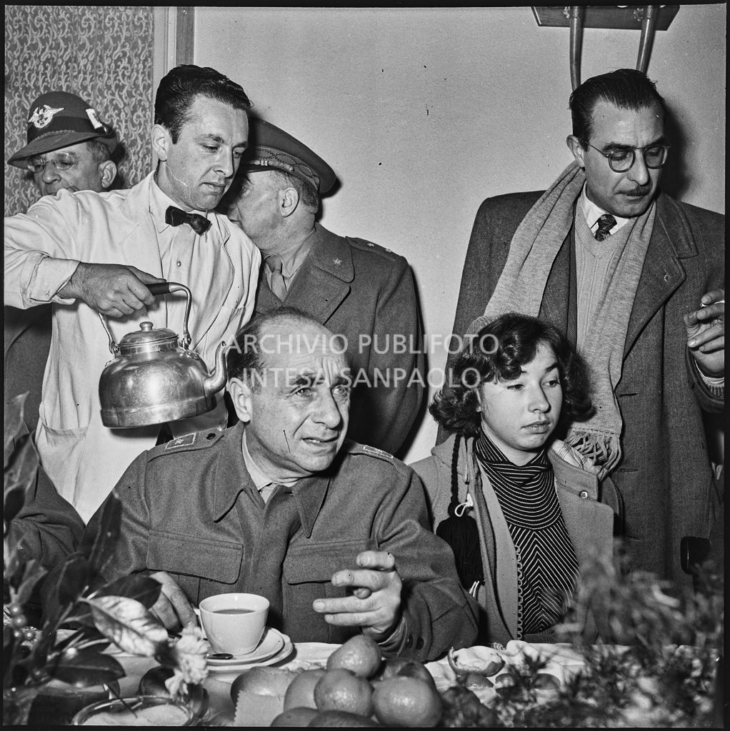 Un ex prigioniero italiano di rientro dall'Unione Sovietica fa colazione circondato da persone<br>196498