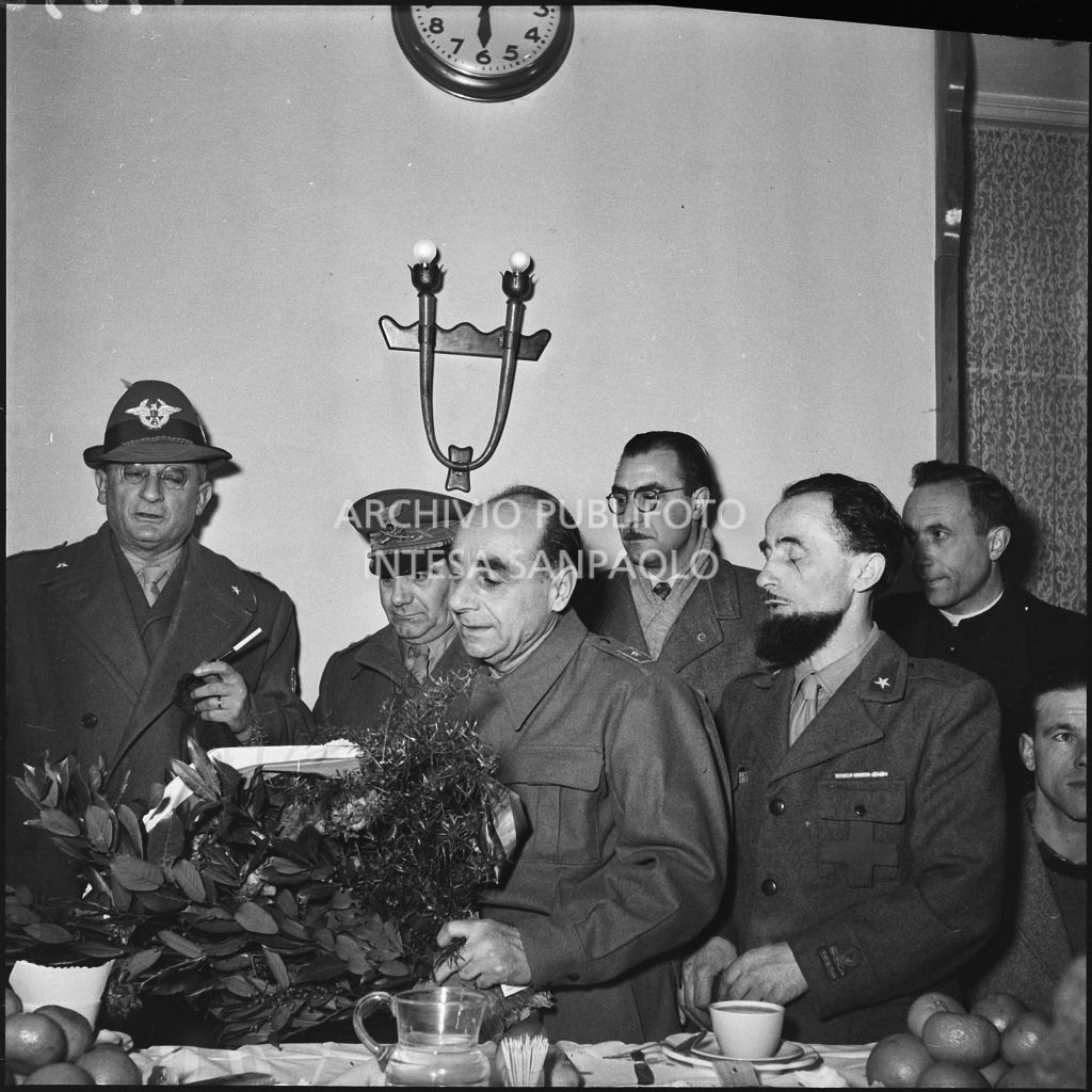 Un sottotenente alpino consegna un mazzo di fiori ad un ex prigioniero italiano di ritorno dall'Unione Sovietica<br>196505