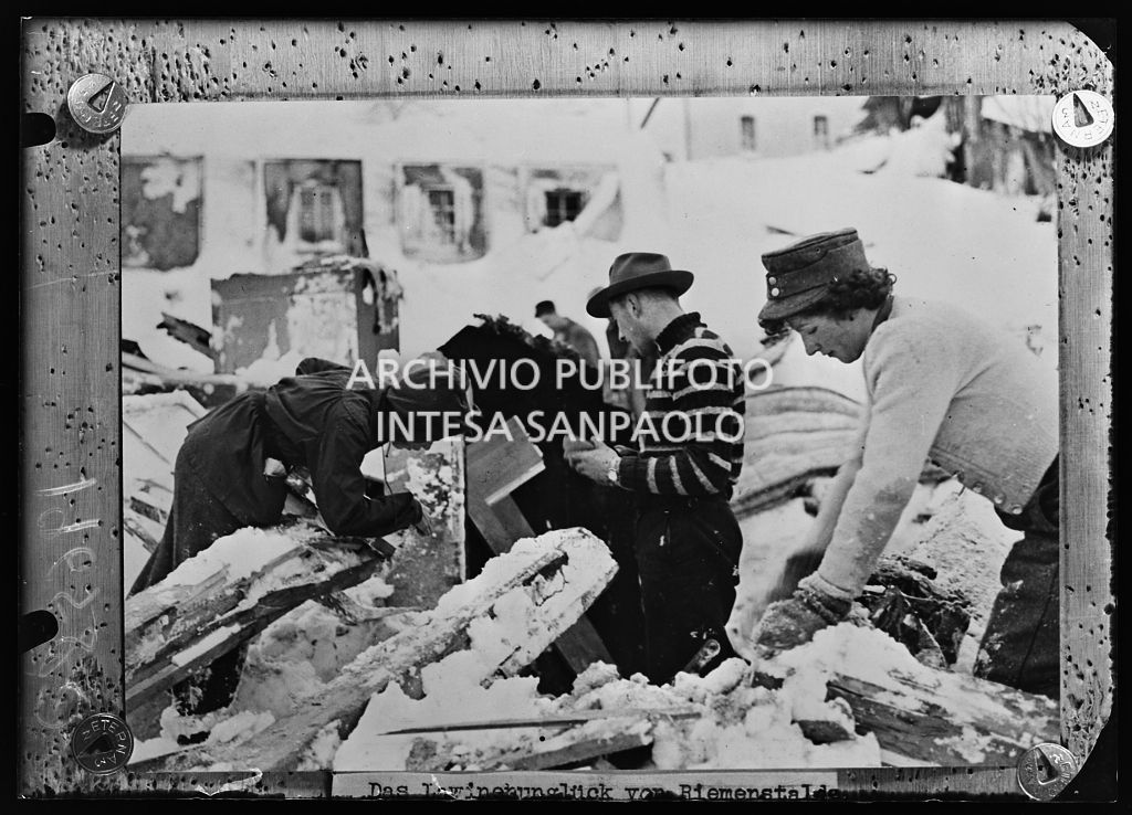 Uomini e donne rovistano tra le macerie dopo una valanga di neve a Riemenstalden<br>196580