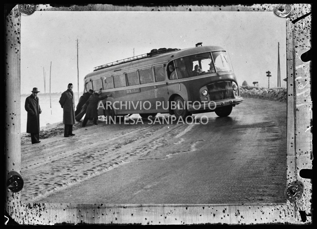 Alcuni uomini cercano di rimettere in carreggiata un autobus che ha sbandato a causa della strada ghiacciata<br>196590