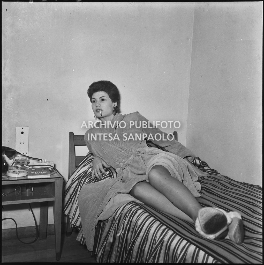 Giuliana Moira Zuccaro in posa su un letto indossa un accappatoio<br>201628