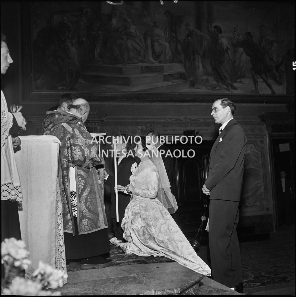 La signorina Cardellini con lo sposo in ginocchio sull'altare della chiesa di Santo Stefano a Sesto San Giovanni durante la cerimonia nuziale<br>201762