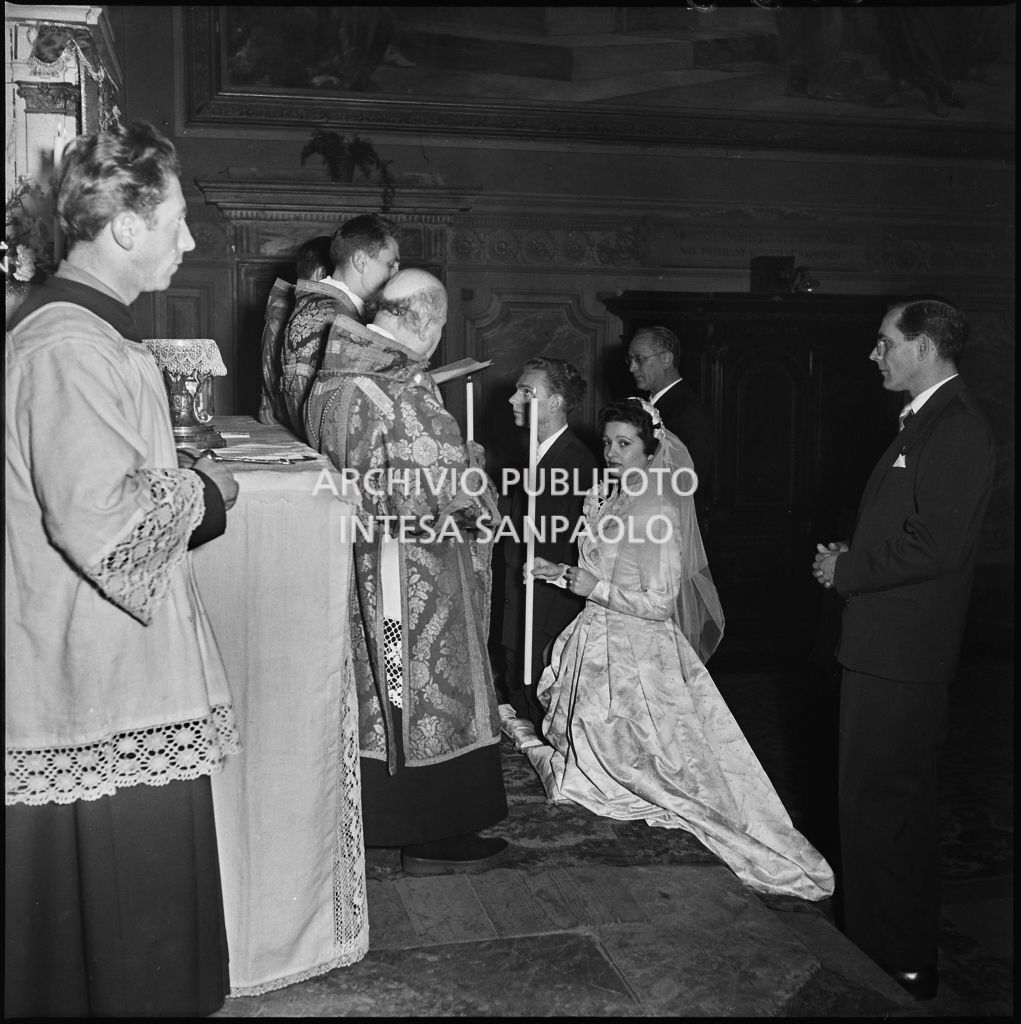 La signorina Cardellini con lo sposo in ginocchio sull'altare della chiesa di Santo Stefano a Sesto San Giovanni durante la cerimonia nuziale<br>201763