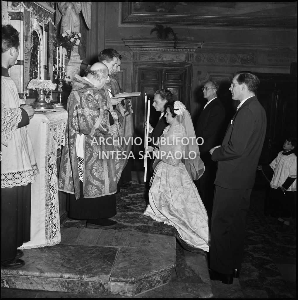 La signorina Cardellini con lo sposo in ginocchio sull'altare della chiesa di Santo Stefano a Sesto San Giovanni durante la cerimonia nuziale<br>201764