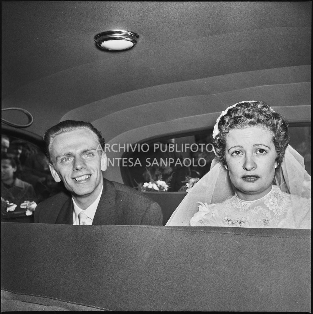 La signorina Cardellini con lo sposo sul sedile posteriore di un'automobile al termine della cerimonia nuziale<br>201773