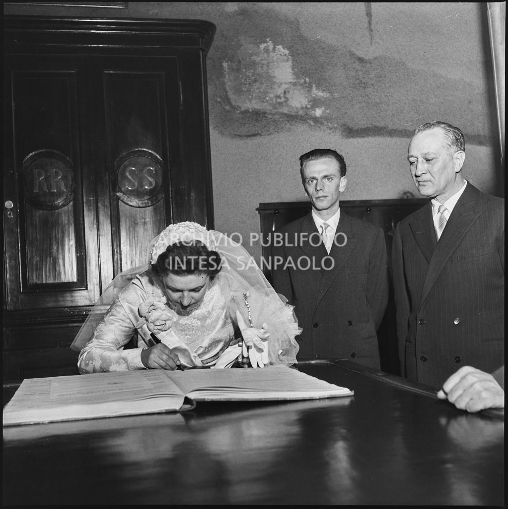 La signorina Cardellini con lo sposo nella sagrestia della chiesa di Santo Stefano a Sesto San Giovanni mentre firma il registro del matrimonio<br>201781