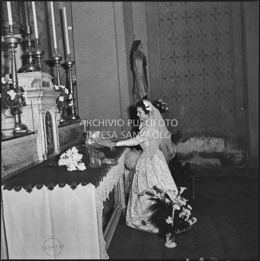La signorina Cardellini appoggia un mazzo di fiori sull'altare della chiesa di Santo Stefano a Sesto San Giovanni durante la cerimonia nuziale<br>201786