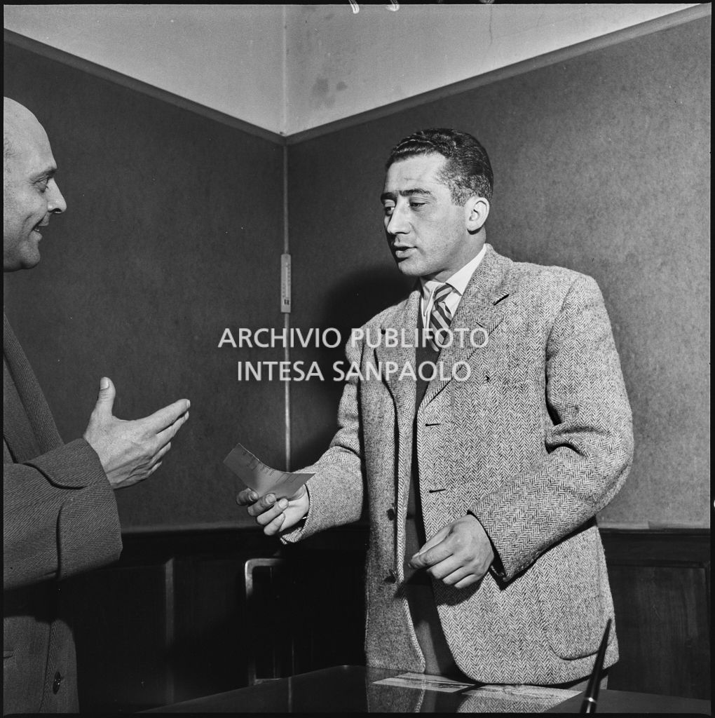 Un membro della Democrazia Cristiana consegna un foglietto ad un uomo<br>201799