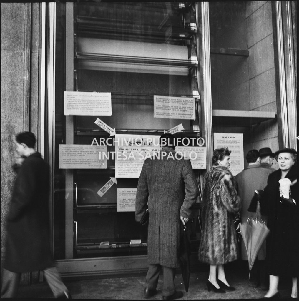Vetrina del negozio Motta nella Galleria Vittorio Emanuele II a Milano con i manifesti del "Regolamento per la disciplina fiscale dei generi soggetti a imposta di consumo"<br>201851
