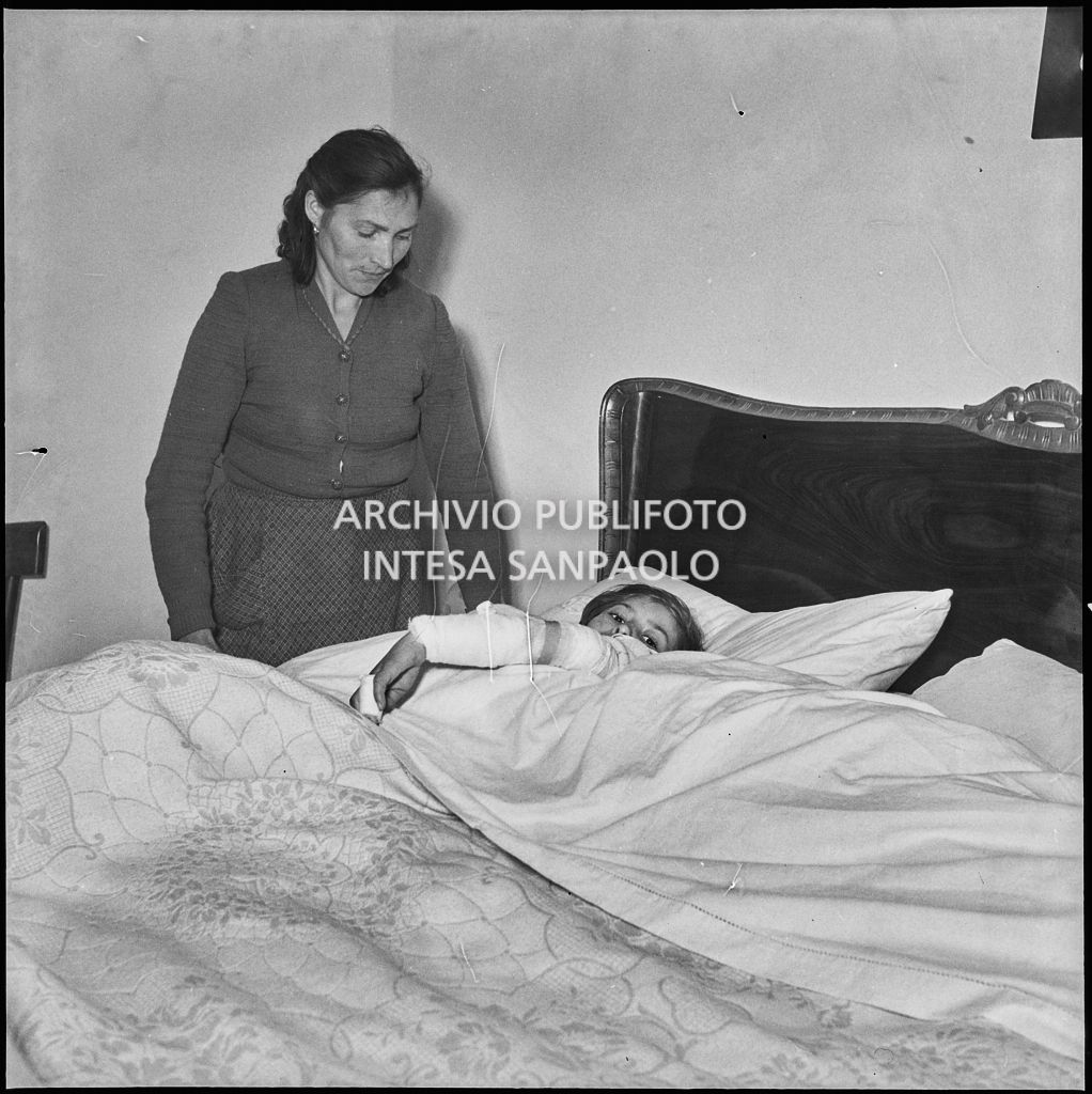 Una bambina ferita a causa dello scoppio di una bomba ad Arese riposa accudita dalla madre<br>201893