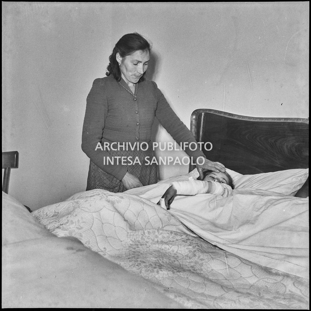 Una bambina ferita a causa dello scoppio di una bomba ad Arese riposa accudita dalla madre<br>201894