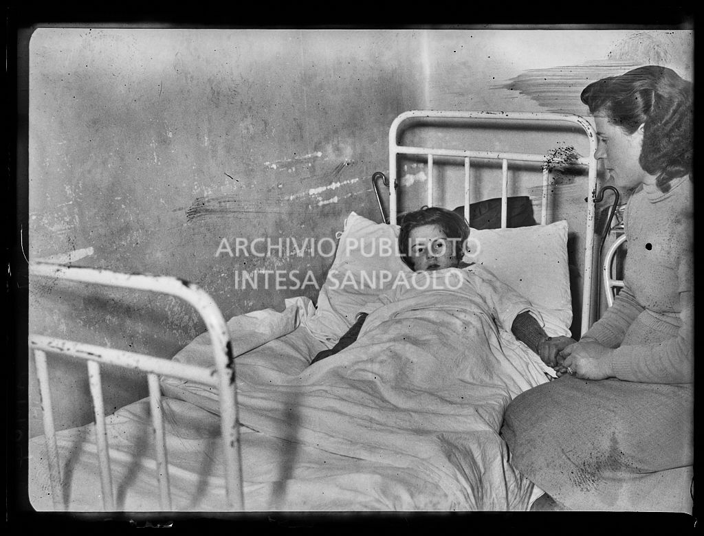 La bambina Antonia Damato, ferita dallo scoppio di una bomba ad Arese, accudita dalla madre<br>201904