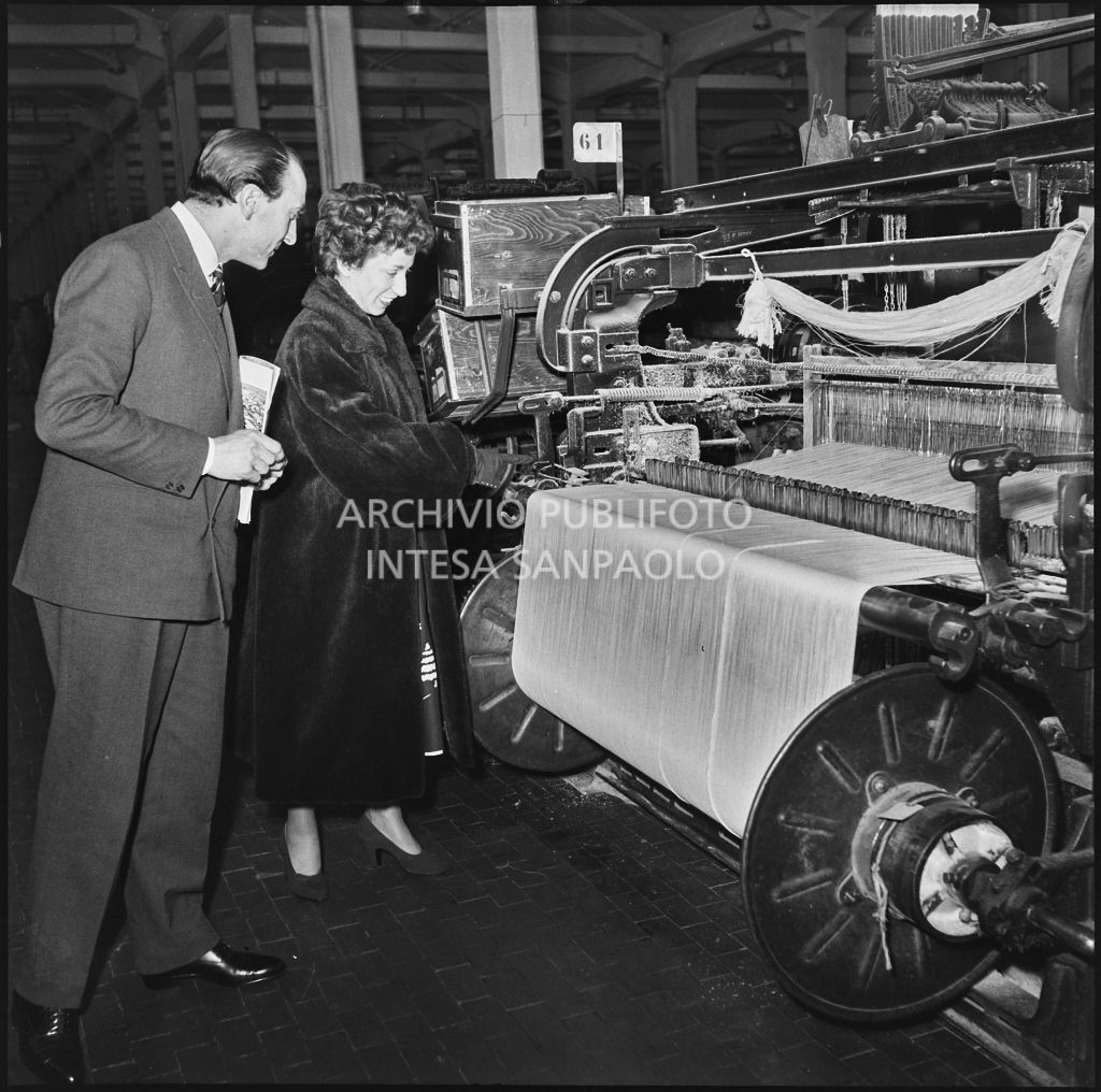 La redattrice di una rivista di moda osserva una macchina per la produzione di tessuti in occasione della visita allo stabilimento del Lanificio Marzotto di Manerbio<br>201956