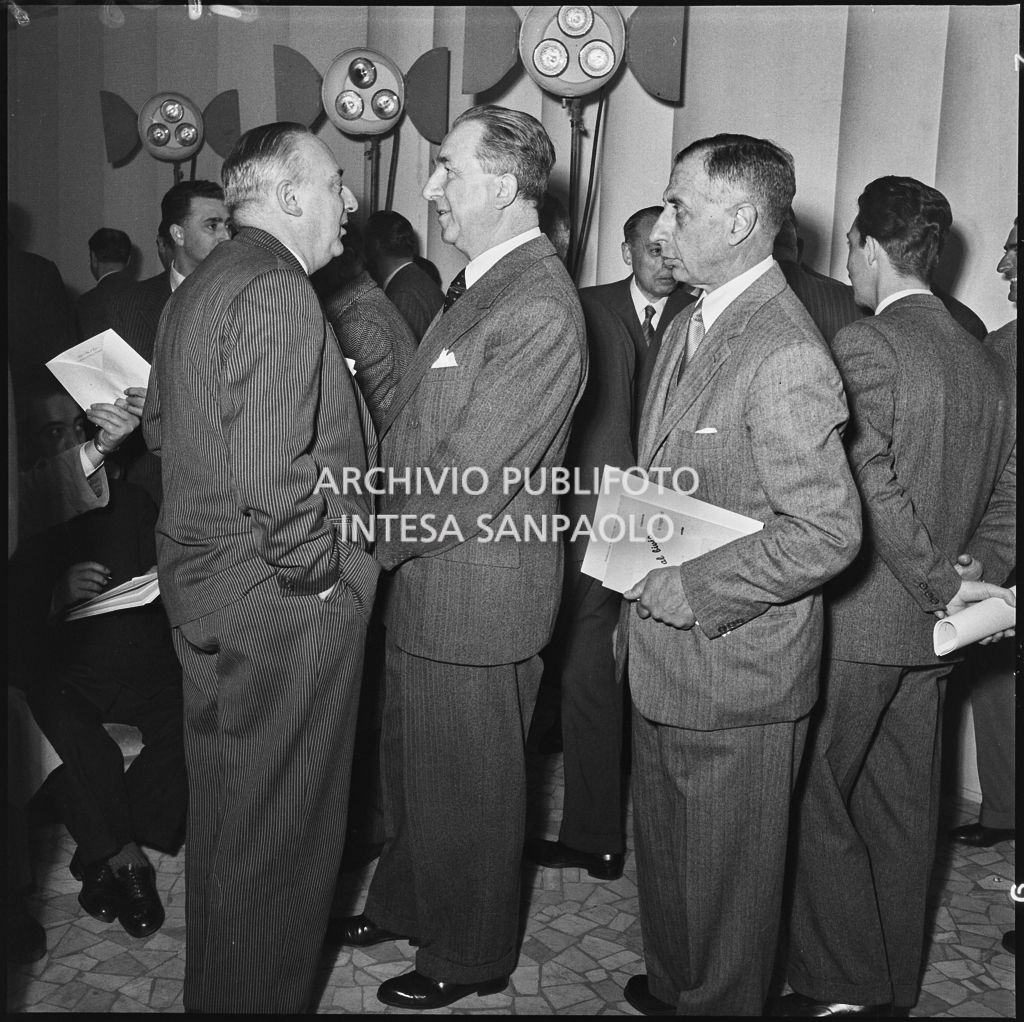 L'onorevole Giuseppe Pella (al centro) conversa con un uomo in occasione del convegno "Human relations" nella sala Puricelli della Fiera campionaria di Milano del 1954<br>210807