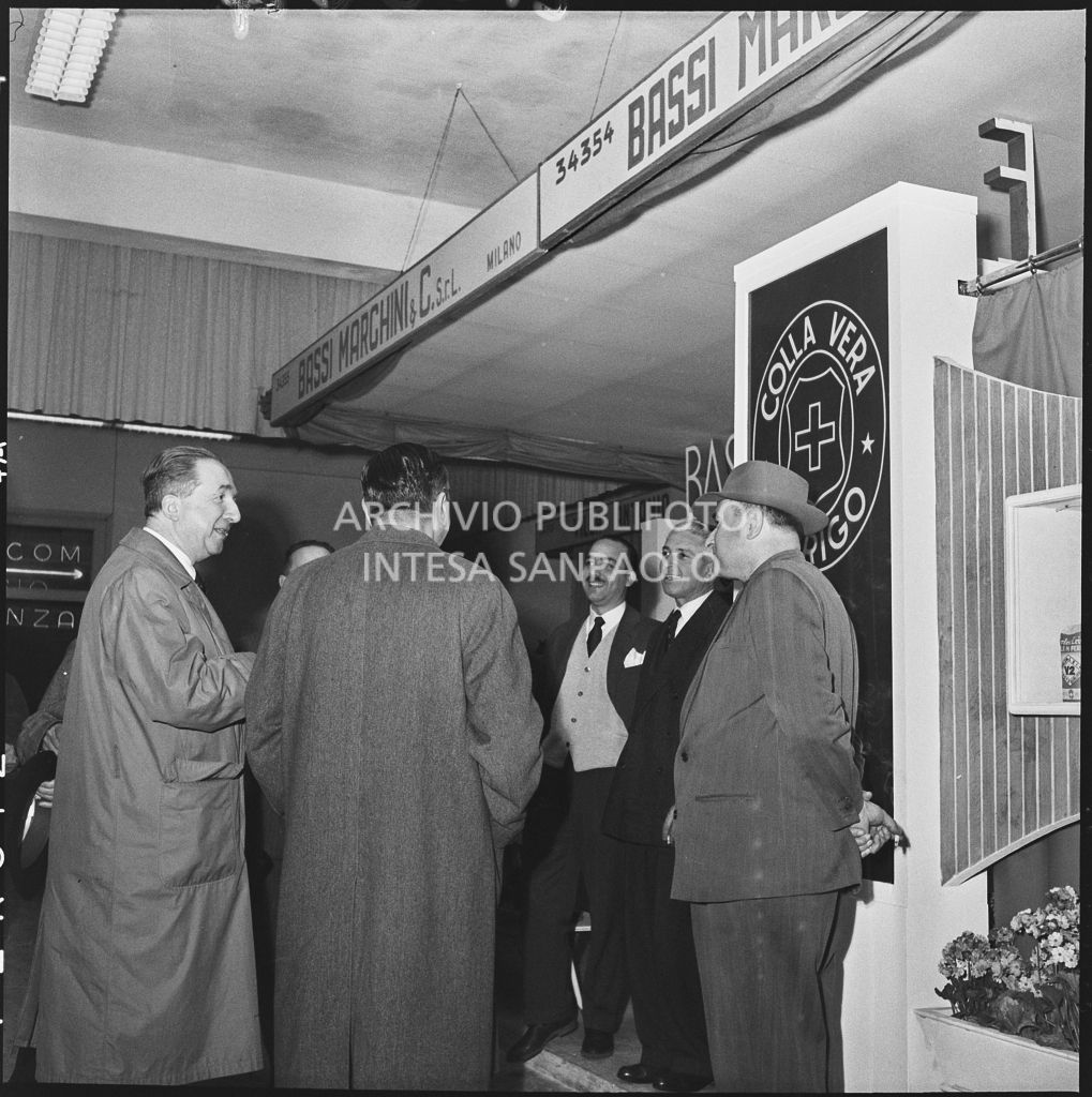 L'onorevole Giuseppe Pella (primo da destra) allo stand del produttore di colla Bassi Marchini alla Fiera Campionaria di Milano del 1954<br>210864