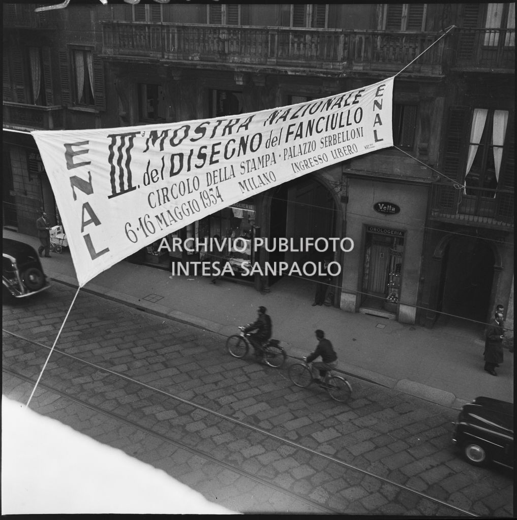 Striscione della III Mostra del disegno del fanciullo organizzata dall'ENAL appeso sopra una strada di Milano<br>212252