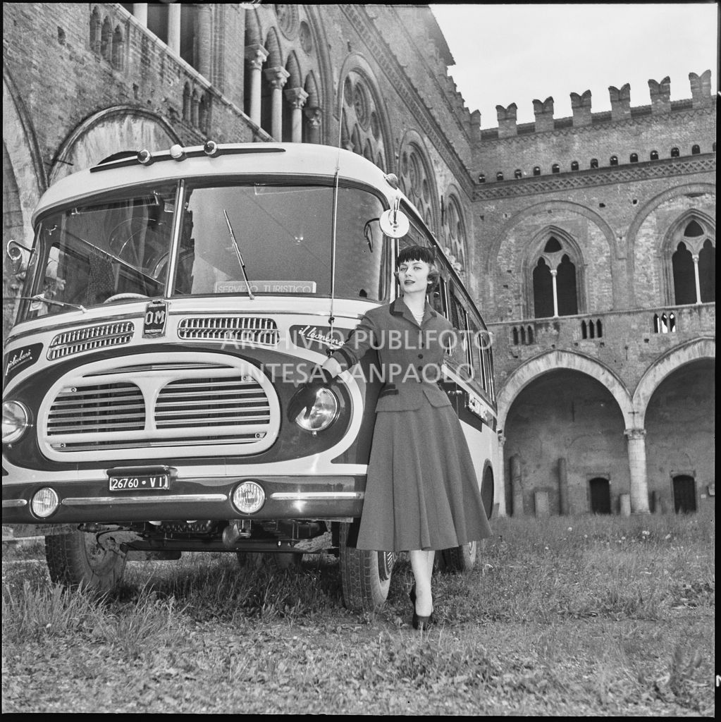 Indossatrice con le creazioni della Marzotto in posa davanti a un autobus nel giardino del castello di Pavia<br>212370