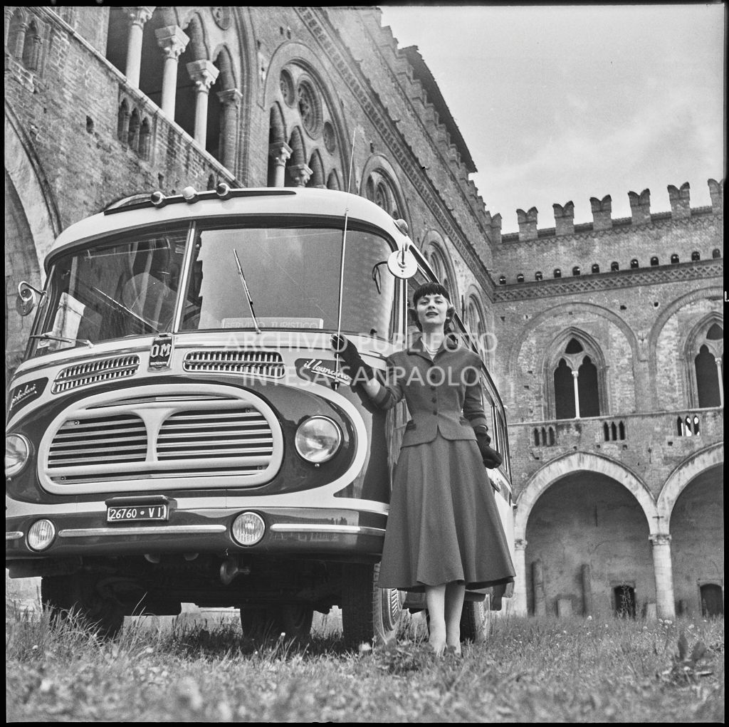 Indossatrice con le creazioni della Marzotto in posa davanti a un autobus nel giardino del castello di Pavia<br>212371