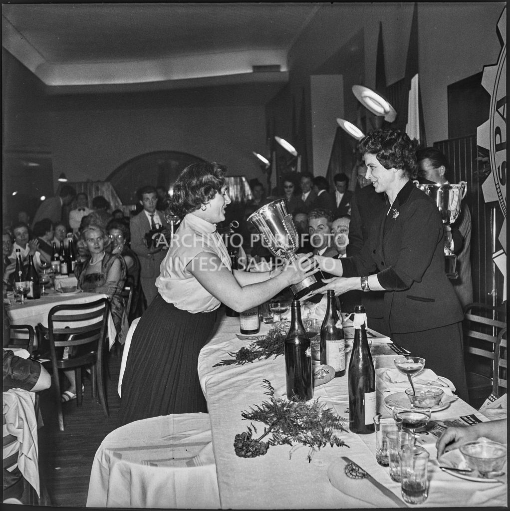 Una donna consegna il premio ad una delle vincitrici della terza edizione dell'Audax internazionale vespistico femminile durante il banchetto organizzato del Vespa Club Milano<br>215312