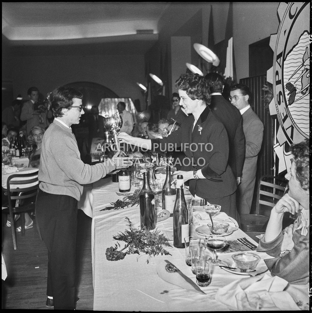 Una donna consegna il premio ad una delle vincitrici della terza edizione dell'Audax internazionale vespistico femminile durante il banchetto organizzato del Vespa Club Milano<br>215321