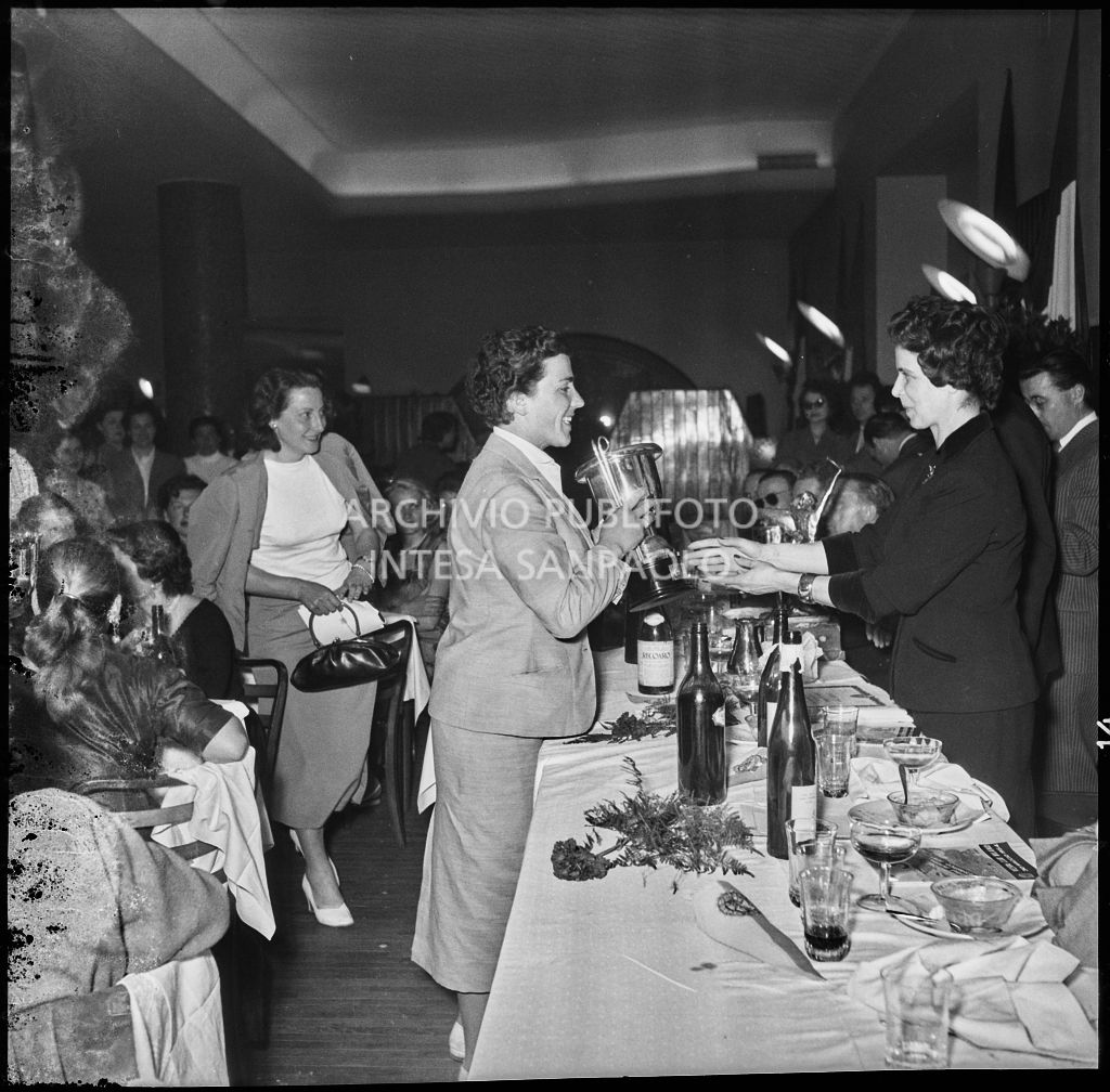 Una donna consegna il premio ad una delle vincitrici della terza edizione dell'Audax internazionale vespistico femminile durante il banchetto organizzato del Vespa Club Milano<br>215324