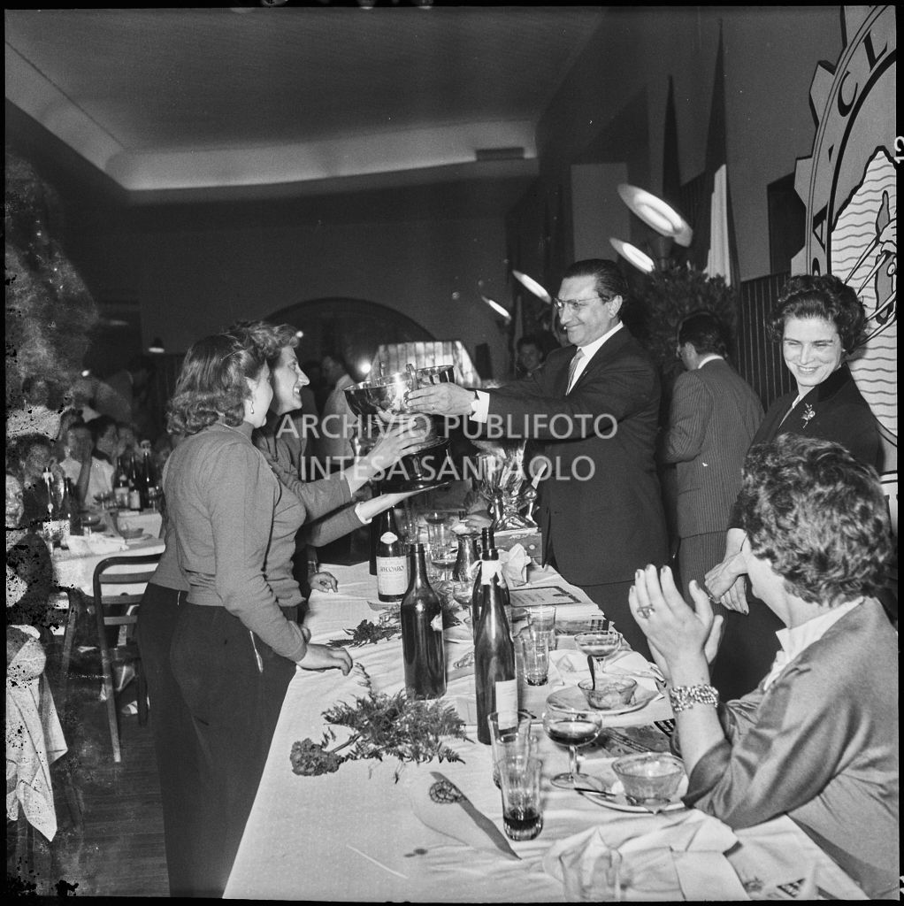 Il presidente del Vespa Club Milano Renato Tassinari consegna il premio ad alcune vincitrici della terza edizione dell'Audax internazionale vespistico femminile durante il banchetto organizzato del Vespa Club Milano<br>215325