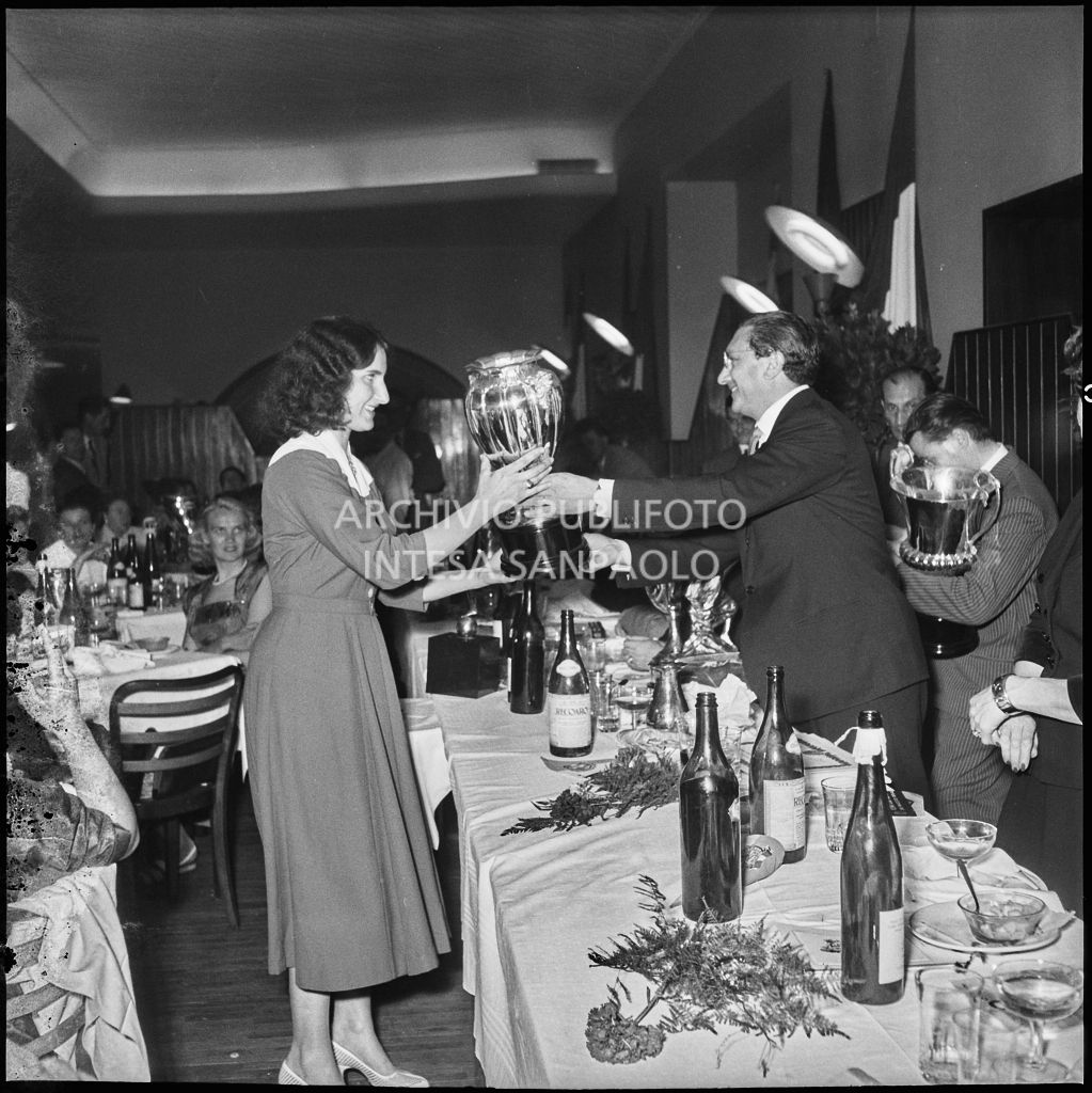 Il presidente del Vespa Club Milano Renato Tassinari consegna il premio ad una delle vincitrici della terza edizione dell'Audax internazionale vespistico femminile durante il banchetto organizzato del Vespa Club Milano<br>215329