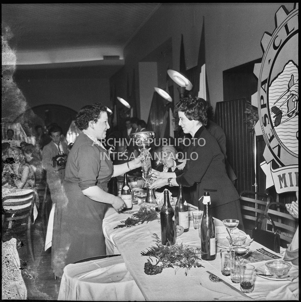 Una donna consegna il premio ad una delle vincitrici della terza edizione dell'Audax internazionale vespistico femminile durante il banchetto organizzato del Vespa Club Milano<br>215330