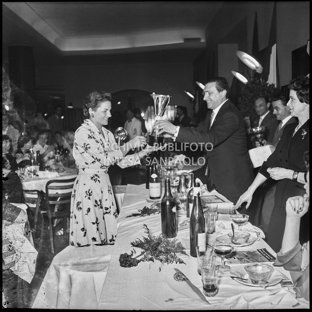 Il presidente del Vespa Club Milano Renato Tassinari consegna il premio ad una delle vincitrici della terza edizione dell'Audax internazionale vespistico femminile durante il banchetto organizzato del Vespa Club Milano<br>215331