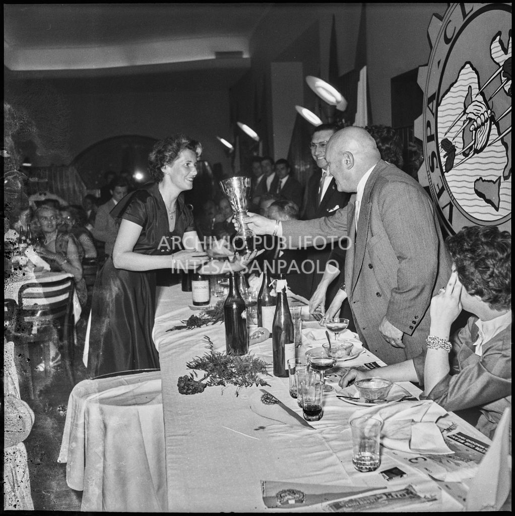 Un uomo consegna il premio ad una delle vincitrici della terza edizione dell'Audax internazionale vespistico femminile durante il banchetto organizzato del Vespa Club Milano<br>215332