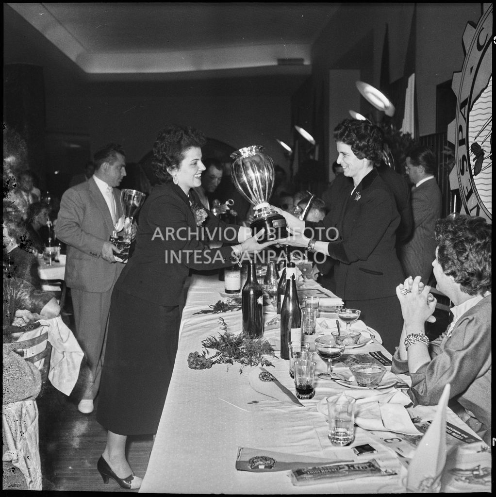 Una donna consegna il premio ad una delle vincitrici della terza edizione dell'Audax internazionale vespistico femminile durante il banchetto organizzato del Vespa Club Milano<br>215333