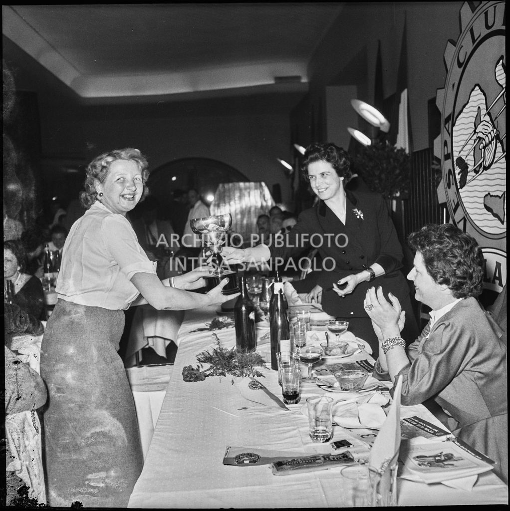 Una donna consegna il premio ad una delle vincitrici della terza edizione dell'Audax internazionale vespistico femminile durante il banchetto organizzato del Vespa Club Milano<br>215334
