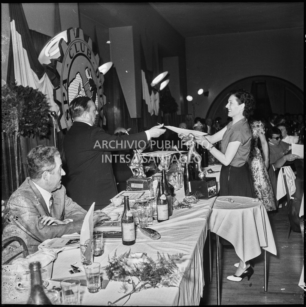 Un uomo consegna l'attestato ad una delle vincitrici della terza edizione dell'Audax internazionale vespistico femminile durante il banchetto organizzato del Vespa Club Milano<br>215335