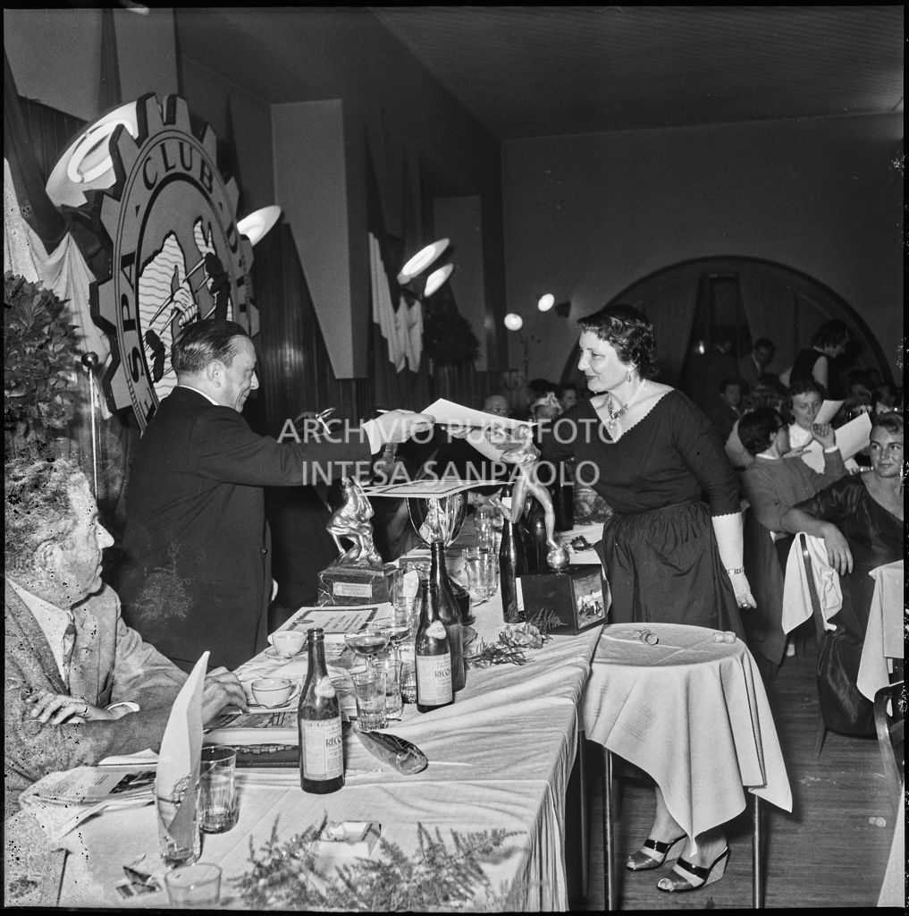 Un uomo consegna l'attestato ad una delle vincitrici della terza edizione dell'Audax internazionale vespistico femminile durante il banchetto organizzato del Vespa Club Milano<br>215336