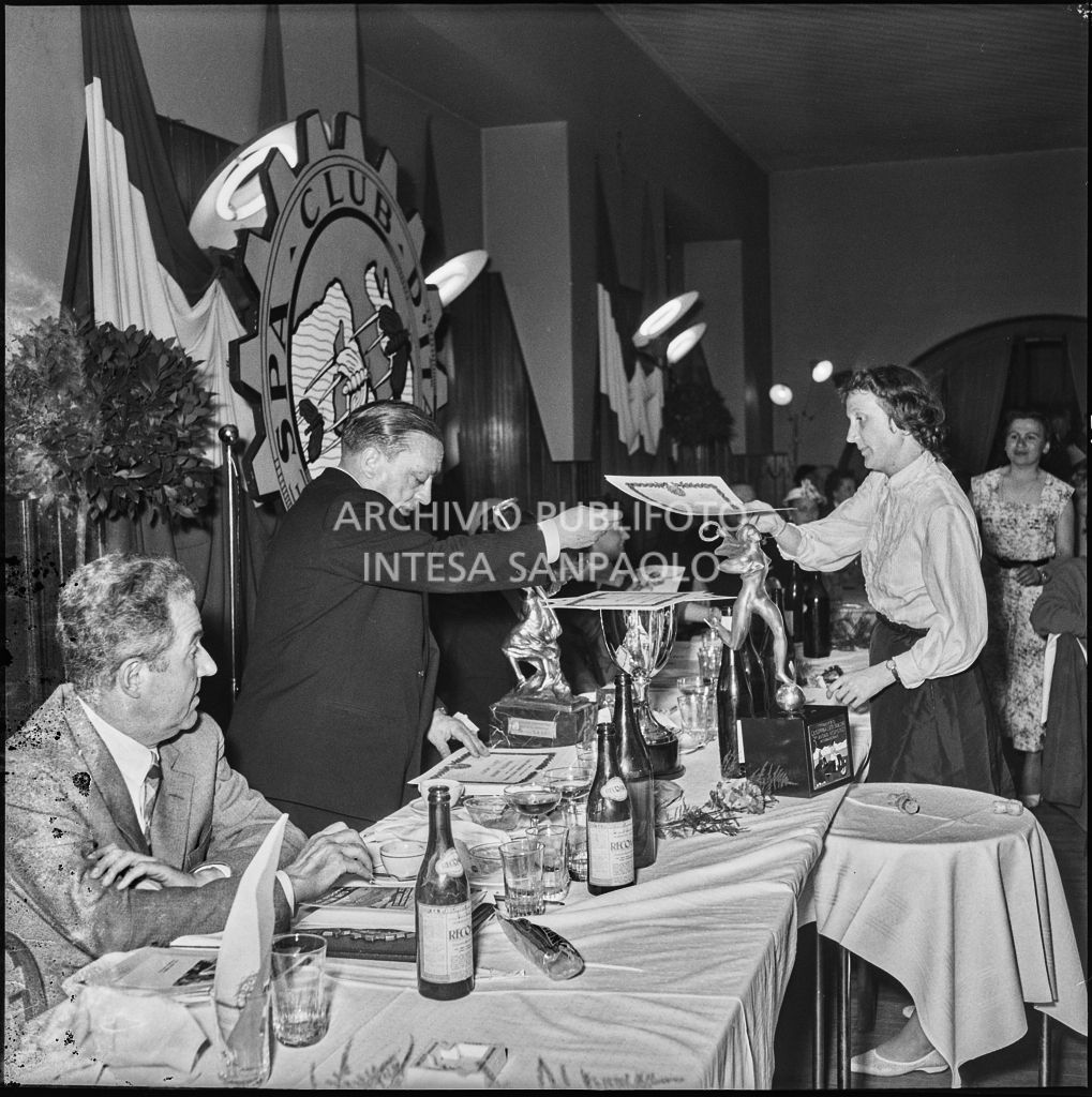 Un uomo consegna l'attestato ad una delle vincitrici della terza edizione dell'Audax internazionale vespistico femminile durante il banchetto organizzato del Vespa Club Milano<br>215337