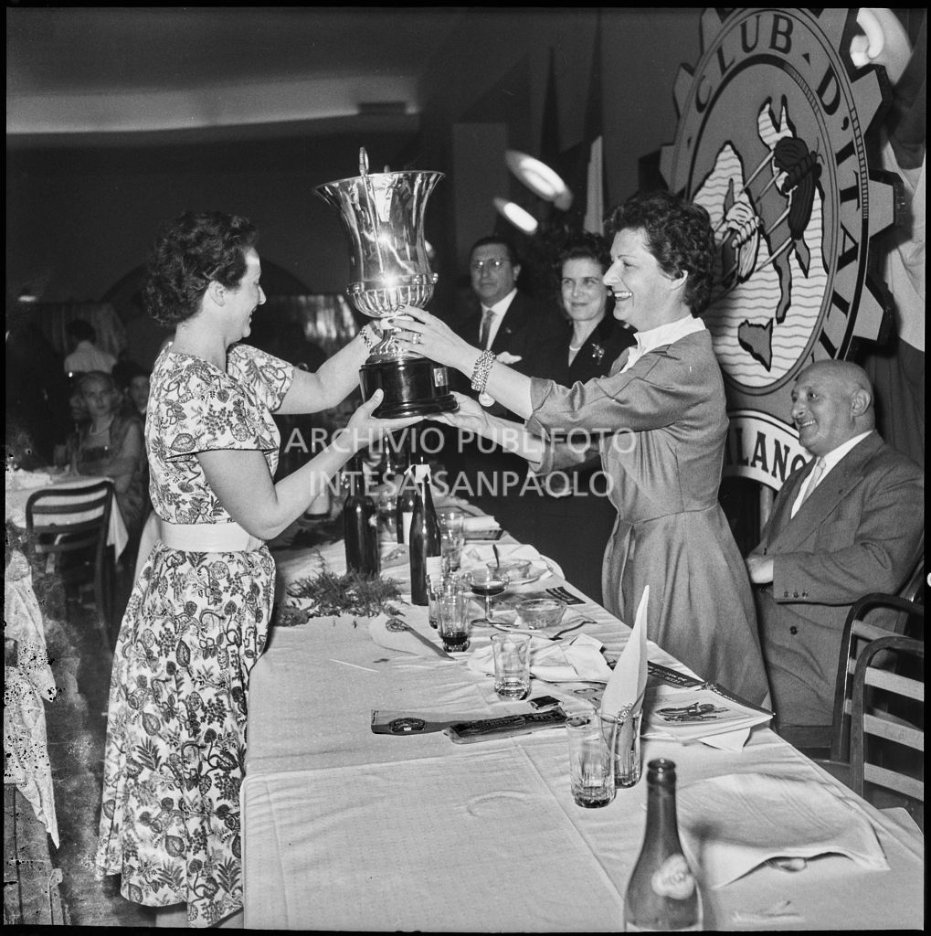 Una donna consegna un premio ad una delle vincitrici della terza edizione dell'Audax internazionale vespistico femminile durante il banchetto organizzato del Vespa Club Milano<br>215342