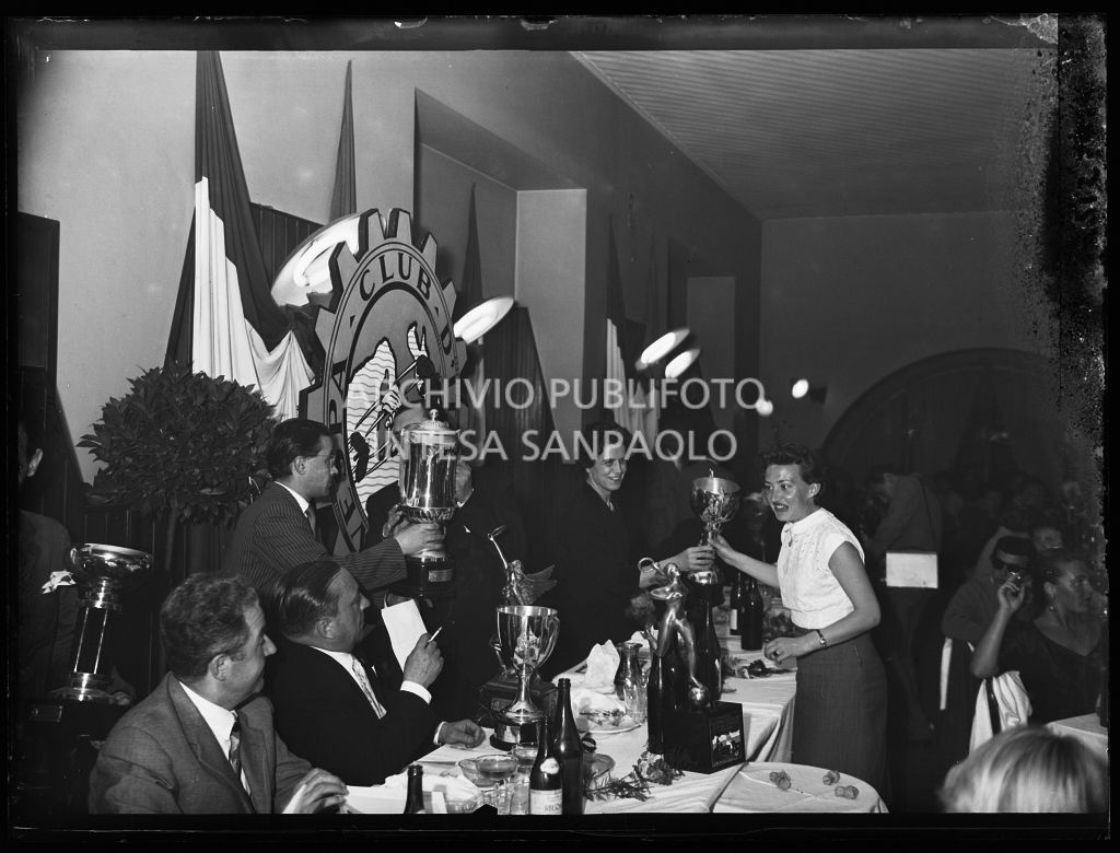 Il presidente del Vespa Club Milano Renato Tassinari ed una donna consegnano i premi alle vincitrici della terza edizione dell'Audax internazionale vespistico femminile durante il banchetto organizzato del Vespa Club Milano<br>215348