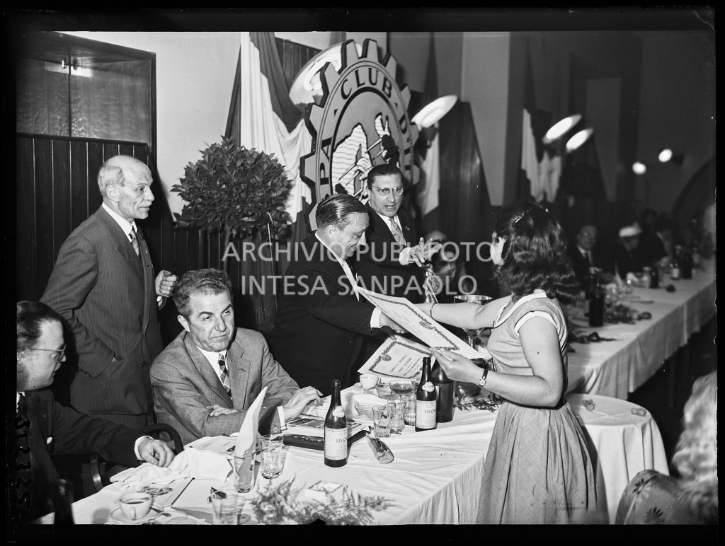 Un uomo consegna l'attestato ad una delle partecipanti alla terza edizione dell'Audax internazionale vespistico femminile durante il banchetto organizzato del Vespa Club Milano. Alla sua sinistra il presidente del Vespa Club Milano Renato Tassinari<br>215352