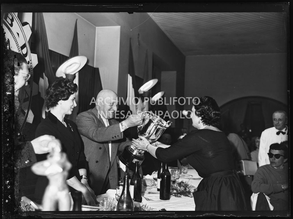 Un uomo consegna un premio ad una delle vincitrici della terza edizione dell'Audax internazionale vespistico femminile durante il banchetto organizzato del Vespa Club Milano<br>215356