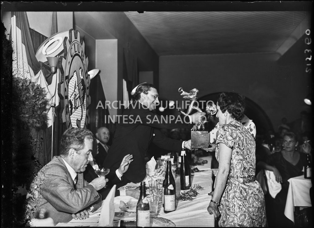 Il presidente del Vespa Club Milano Renato Tassinari consegna un premio a due vincitrici della terza edizione dell'Audax internazionale vespistico femminile durante il banchetto organizzato del Vespa Club Milano<br>215360