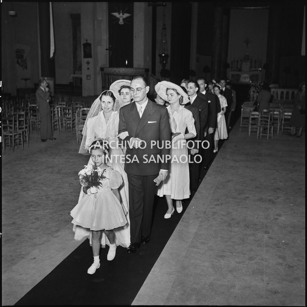 Il signor Rizzi, la moglie e gli invitati percorrono la navata centrale della chiesa al termine della cerimonia nuziale<br>215435