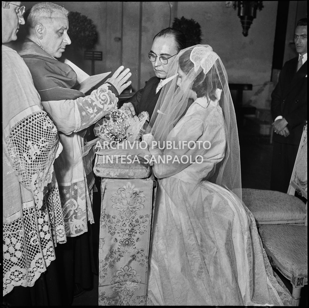 Gli sposi in ginocchio davanti al prete durate la cerimonia nuziale<br>215447