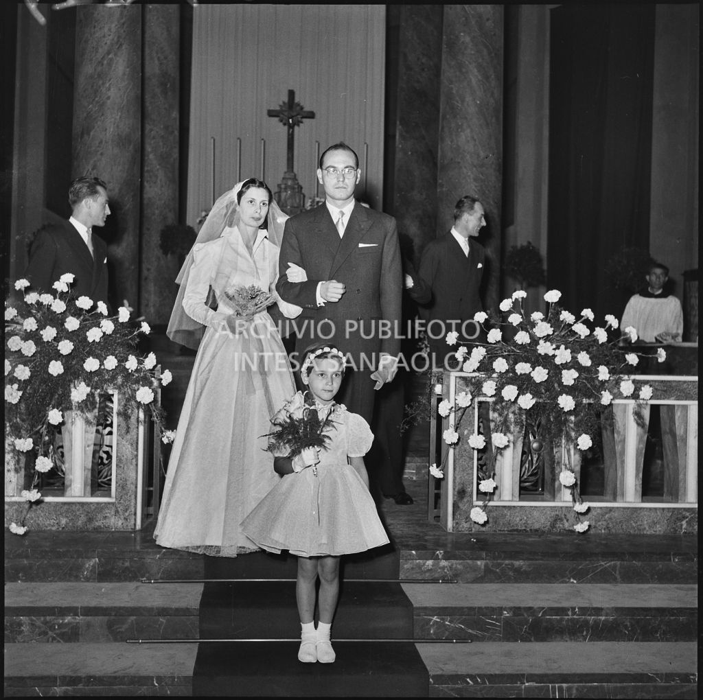 Il signor Rizzi, la moglie e la giovane damigella sull'altare della chiesa al termine della cerimonia nuziale<br>215449