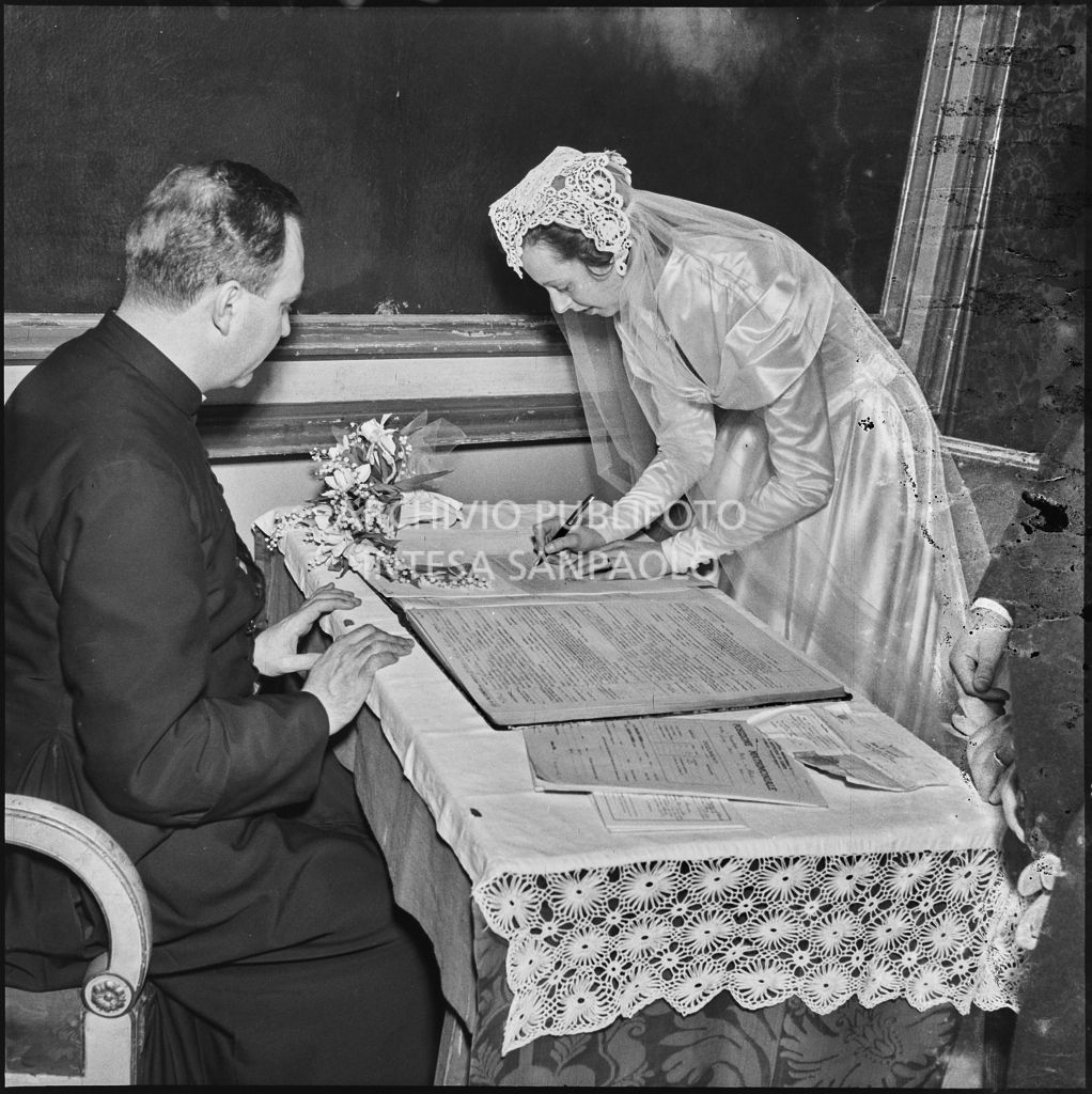 La sposa del dott. Trugenberger firma il registro nuziale al termine della cerimonia svoltasi nella chiesa di San Gottardo in Corte a Milano<br>215777