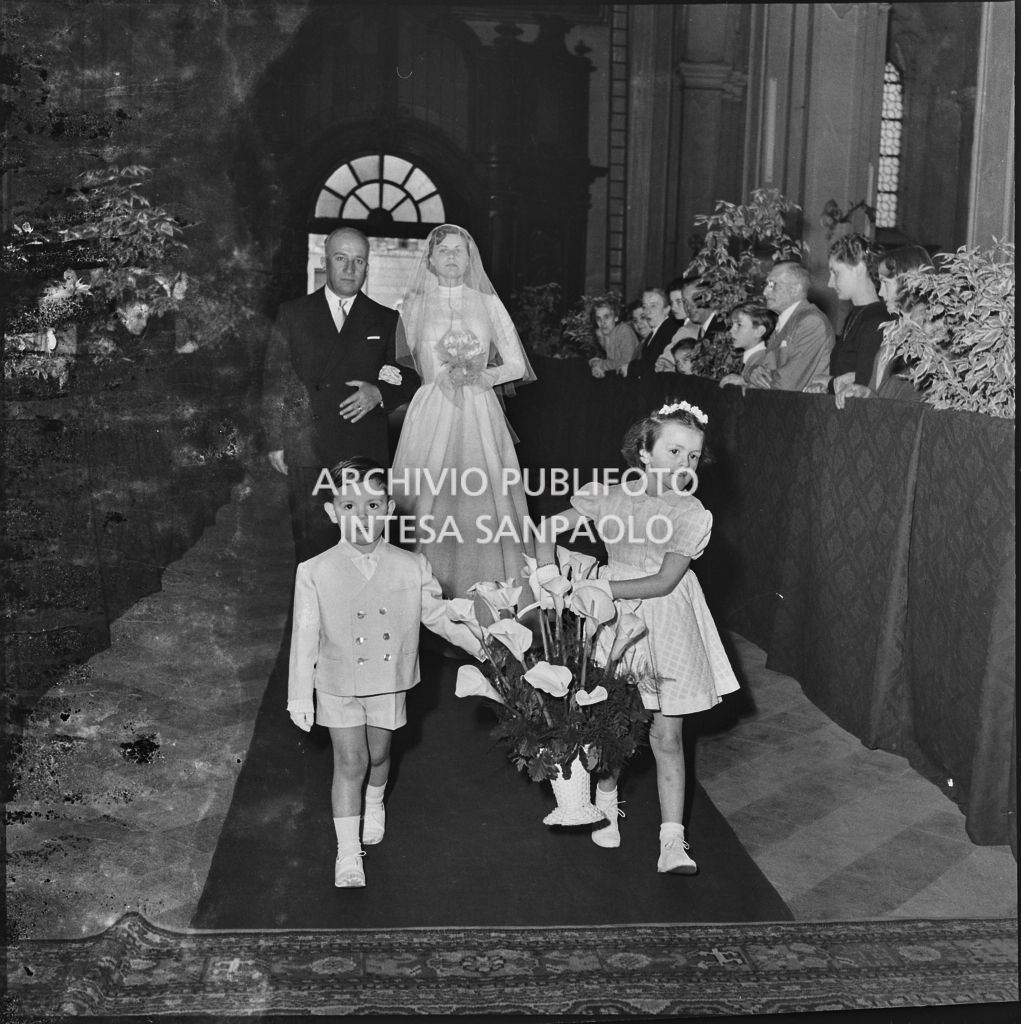 La sposa del dott. Giuseppe Pirovano e il padre percorrono la navata centrale della chiesa di San Marco a Milano in occasione della celebrazione della cerimonia nuziale<br>215928