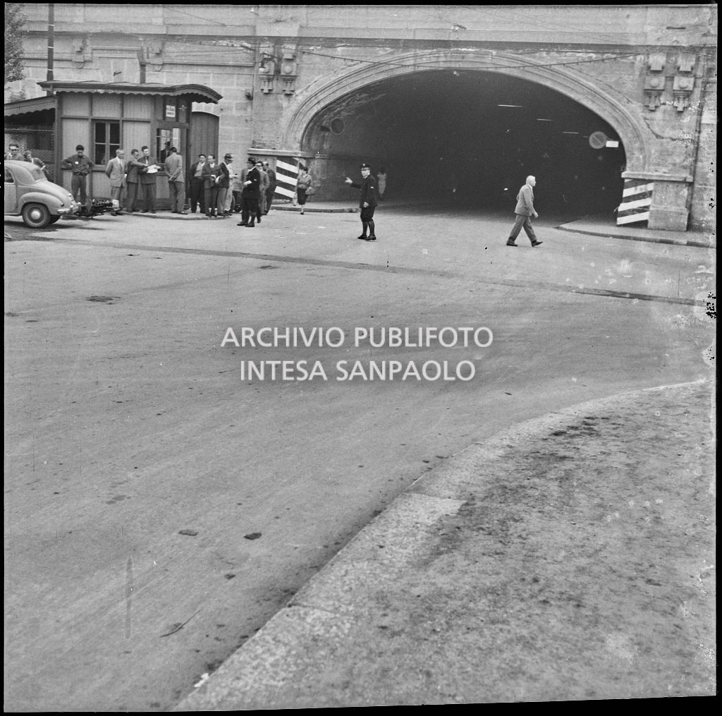 Un agente della polizia dirige  il traffico in seguito u un incidente tra un'automobile Fiat 500 Topolino e una motocicletta avvenuto ad un incrocio di Milano nei pressi di un sottopassaggio<br>216030
