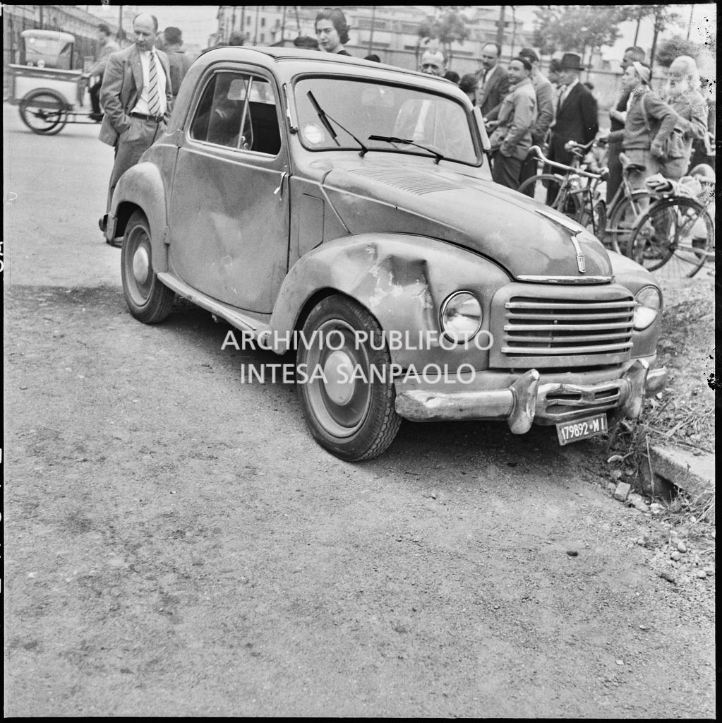Danni subiti da un'automobile Fiat 500 Topolino a seguito di un incidente con una motocicletta avvenuto a un incrocio a Milano nei pressi di un sottopassaggio ferroviario<br>216034